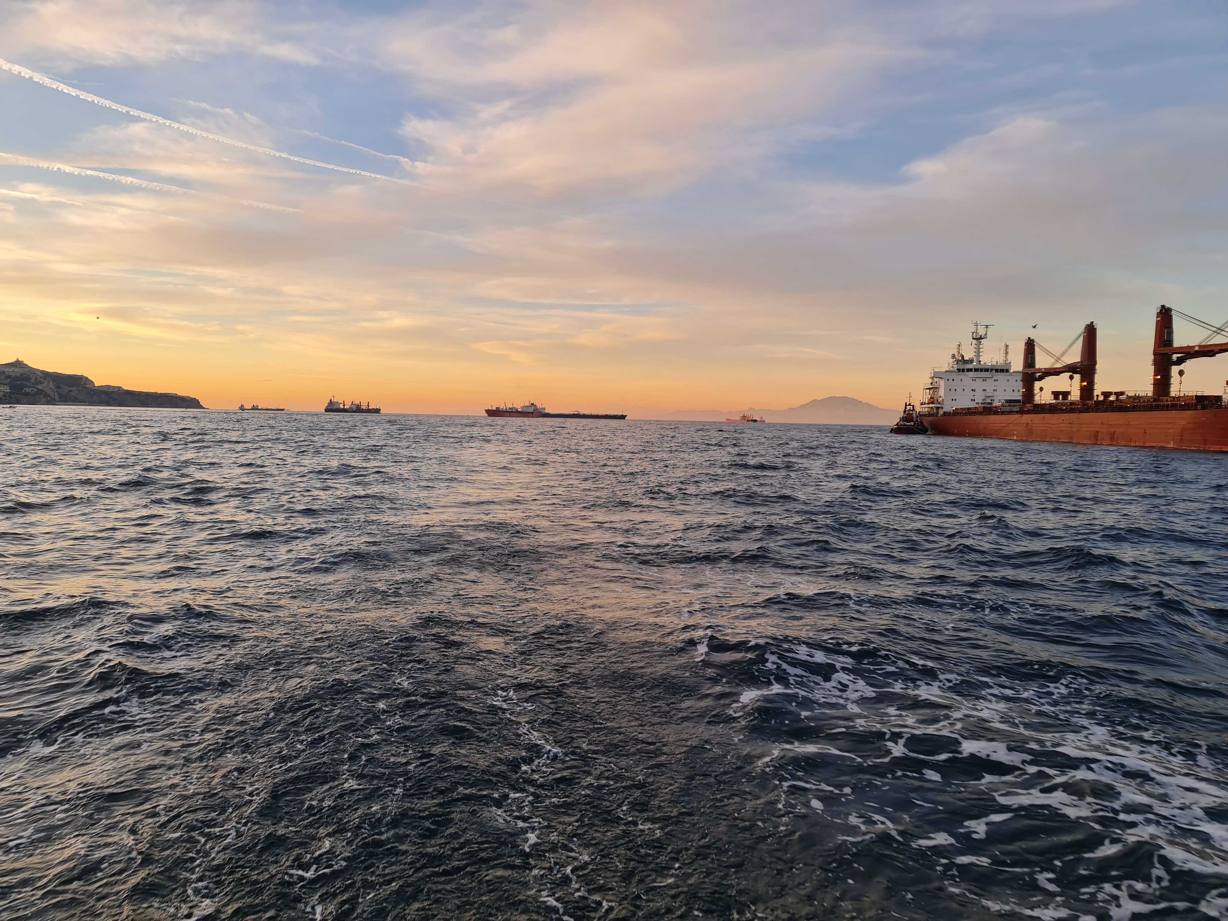 Shipping traffic at sunset - commercial vessels navigating charted waters
